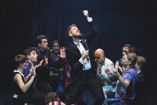 Performer Jim Libby auf einer Bühne mit anderen Schauspielern