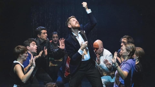 Performer Jim Libby on a stage with actors