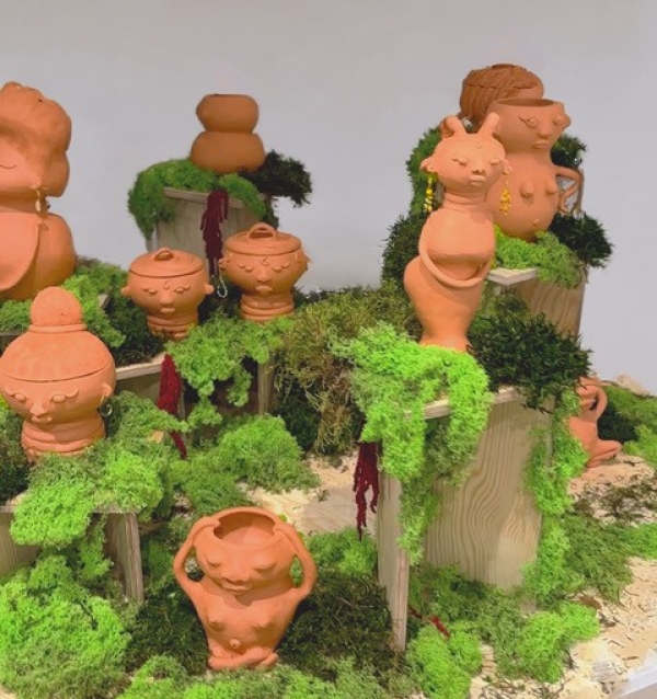 Tonfiguren auf Moos und
                                          Holzobjekten ausgestellt